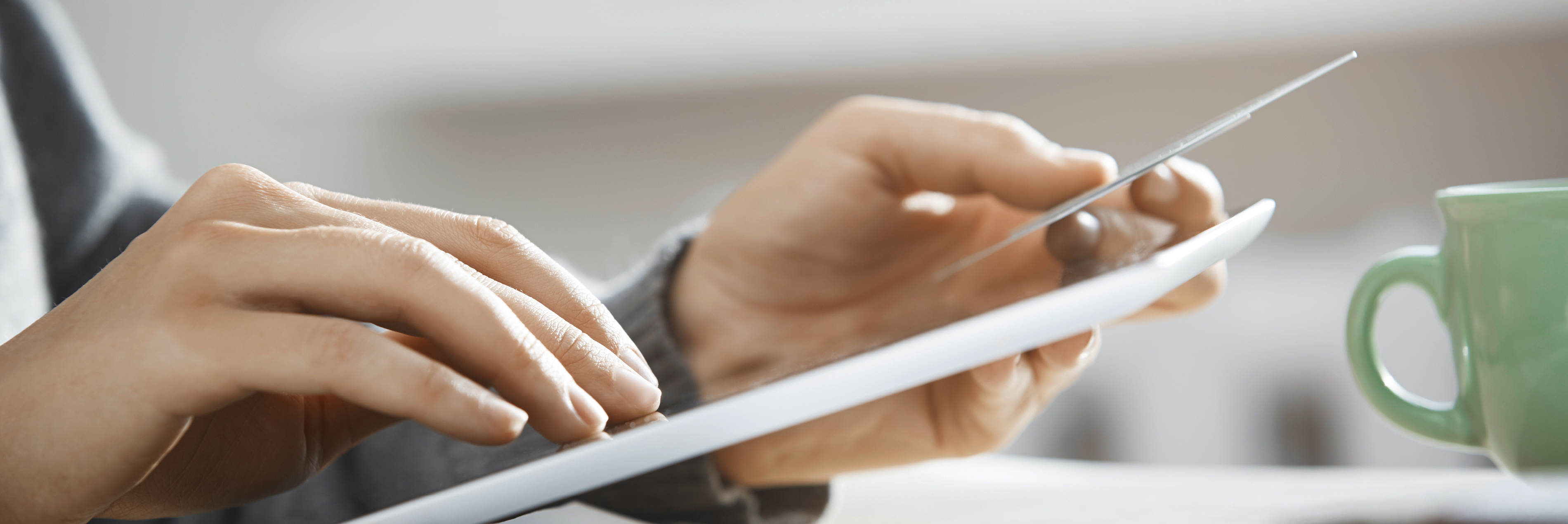 Hands holding tablet and bank card