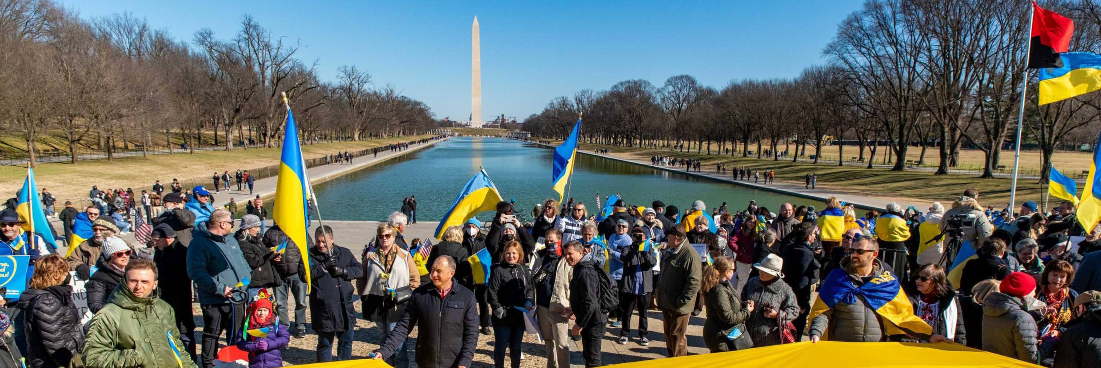 People holding Ukrainian flags in front of the Washington Monument