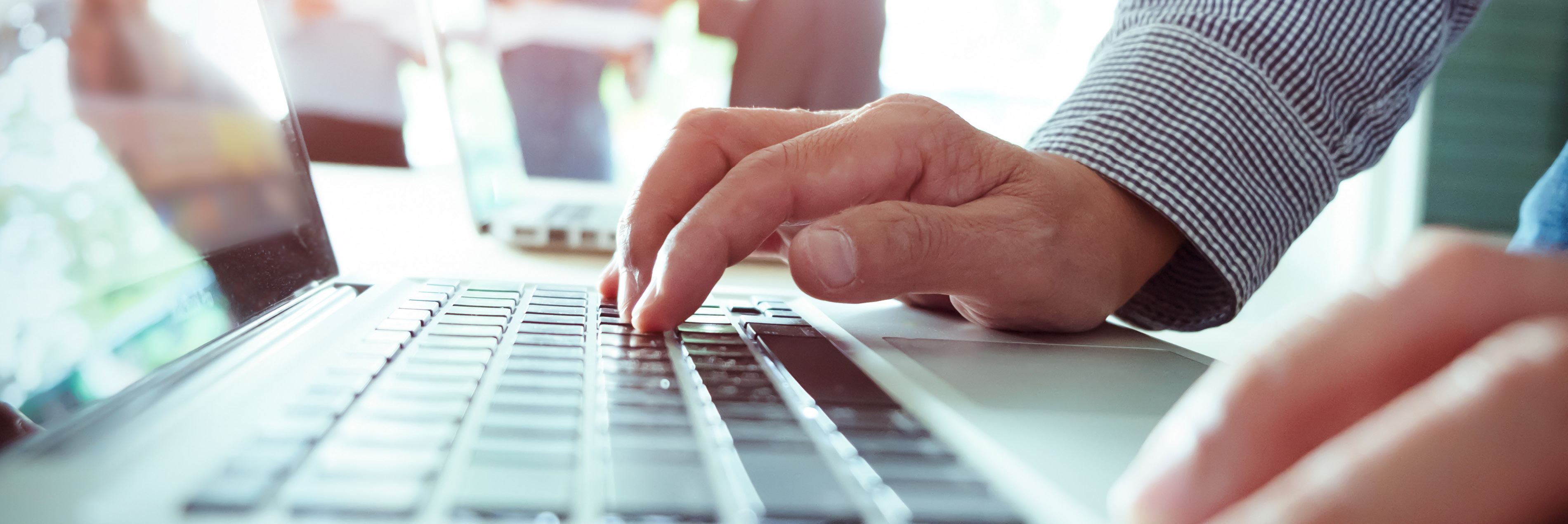 Hands typing on laptop