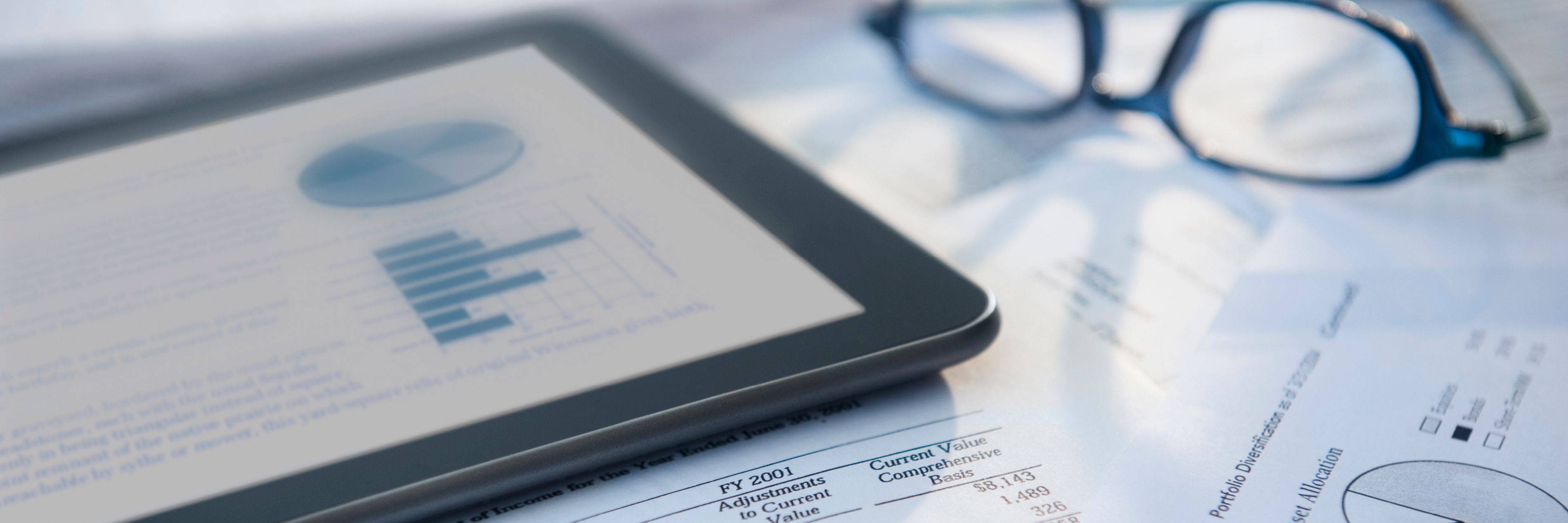 Tablet and financial papers on desk