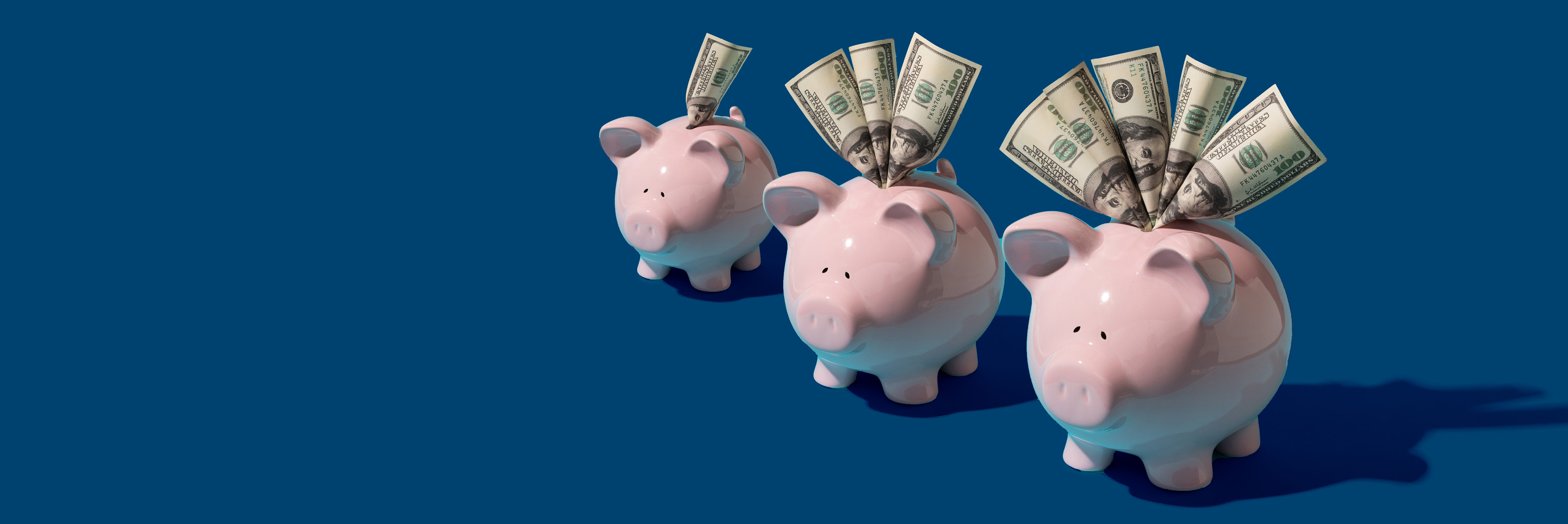 3 piggy banks with dollar bills coming out of the top