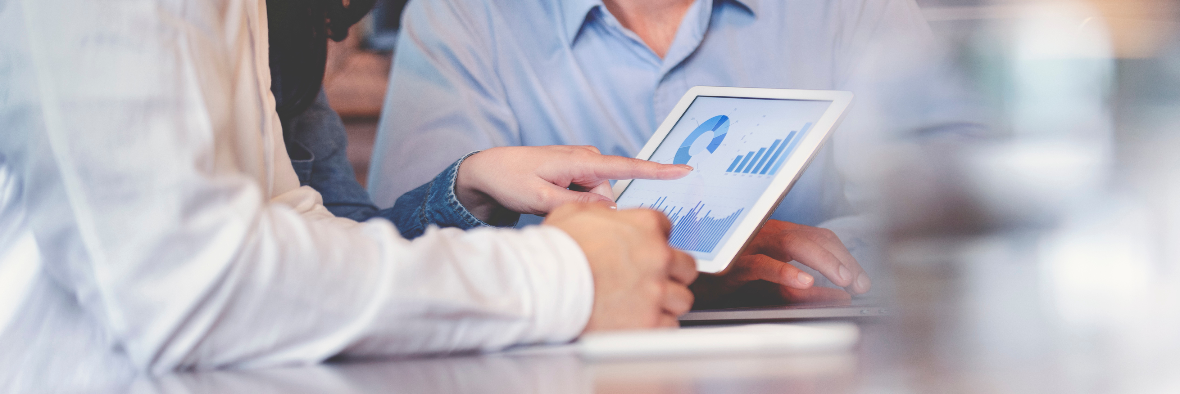 two people looking at charts on a tablet