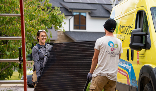 Namaste Solar employees carrying a solar panel