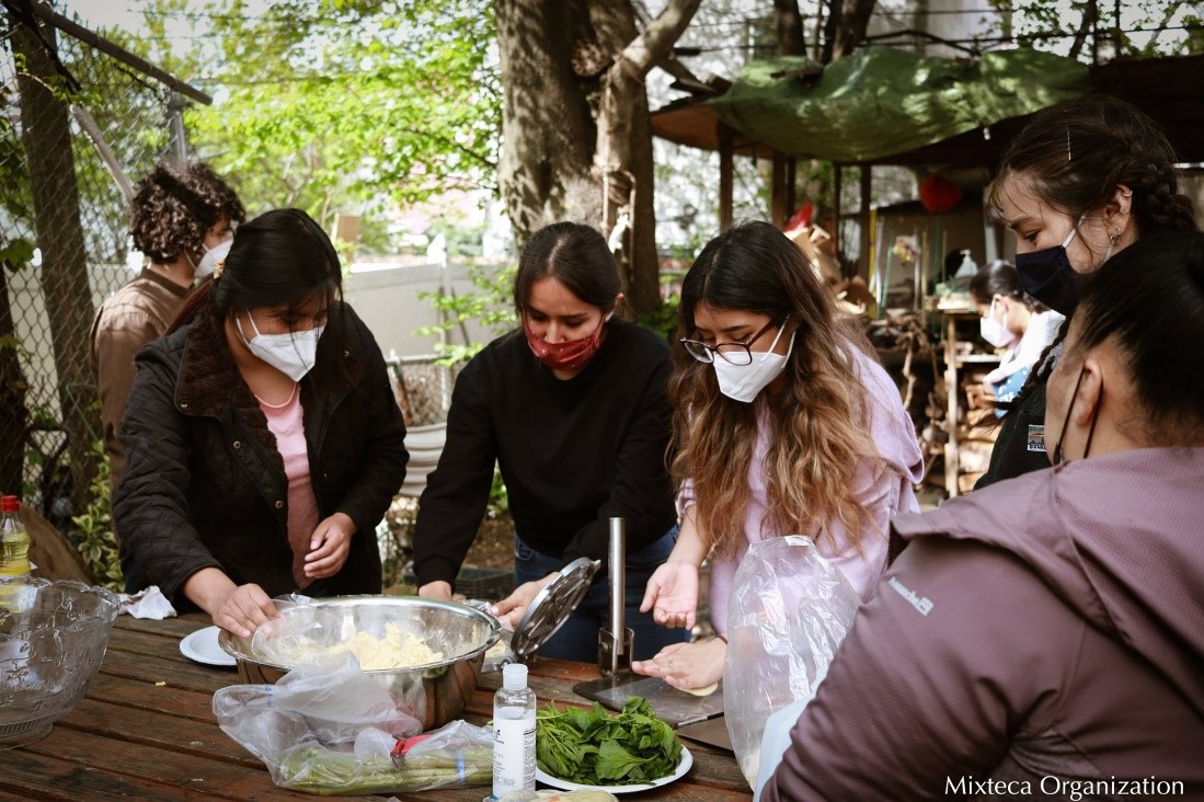 People with facemasks making tortillas